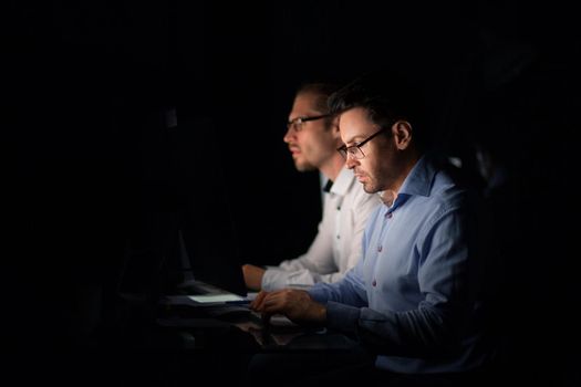 two colleagues sitting at the Desk.isolated on black. photo with copy space