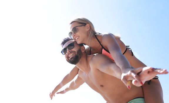 Handsome man giving piggy back to his girlfriend.