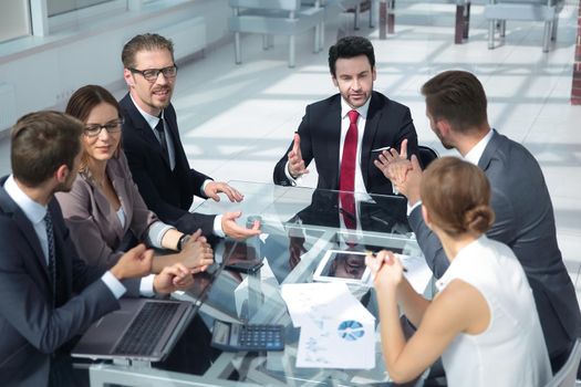 Businessman and businesswoman examining together a document during a working meeting in office
