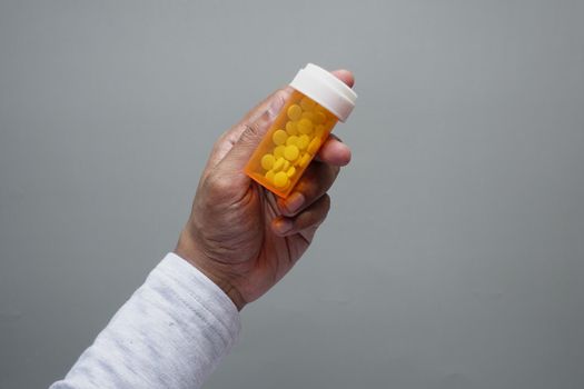 young man hand holding medicine pill container .
