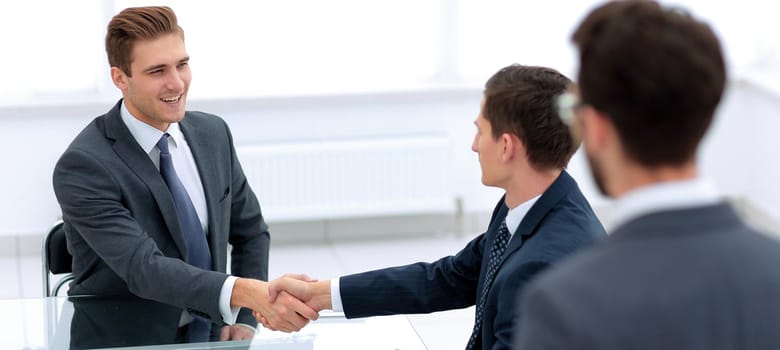 handshake business partners in the office.