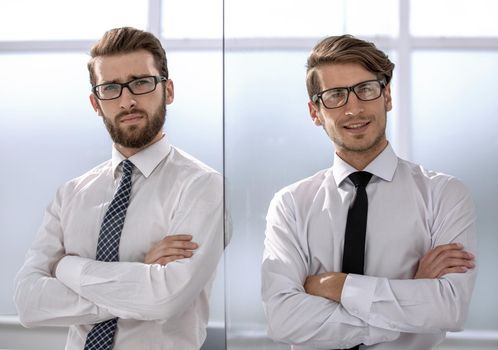 Two happy confident young businessmen standing with arms crossed in office.business concept