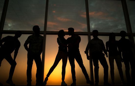 in full growth.a group of young people in the background of a large window