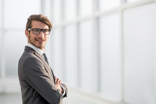 young businessman standing near the office window. photo with copy space