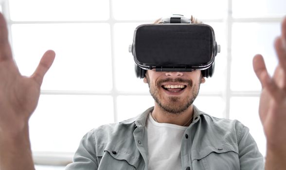 curious man wearing goggles touching 3d virtual objects seem like real