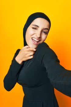 cheerful woman in black hijab posing fashion hand gesture isolated background. High quality photo