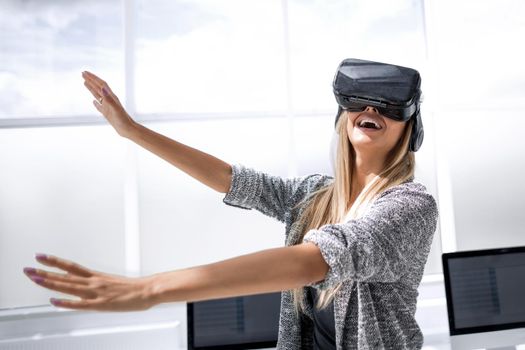Smart innovations. Joyful pretty nice woman holding her hands in front of her and looking at the virtual screen while testing new technologies