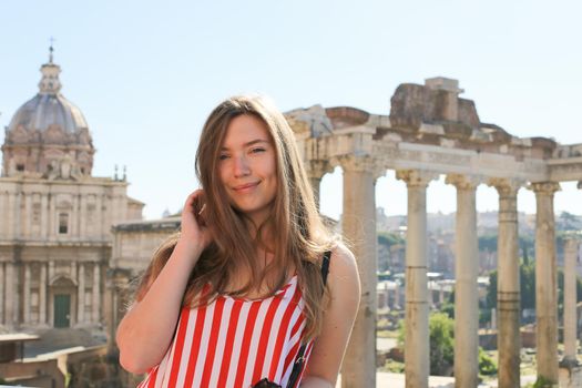 Young woman standing in ruins of Roman Forum background in Rome, Italy. Concept of antique european landmarks and last minute tours.