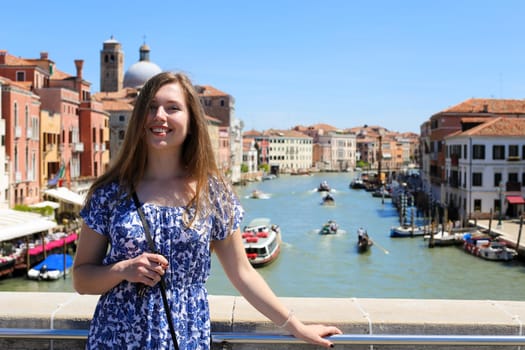 Young female tourist standing in Venice background, Italy. Concept of last minute tours to romantic Europe and amazing summer trip.