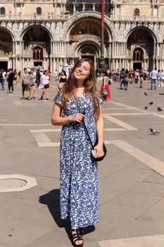 Woman standing on piazza San Marco in Venice, Italy. Concept of tourism and tours to Venetsian landmarks.