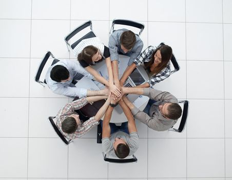 top view.successful business team by folding their hands together. start-up