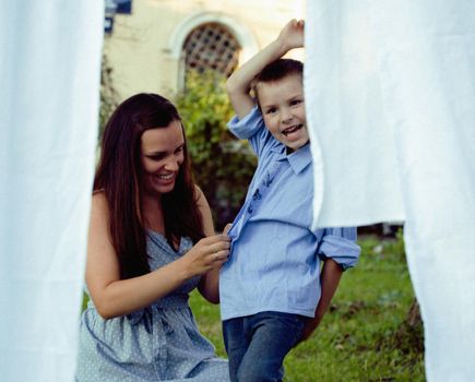 happy real family making laundry outside, children helping