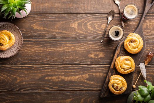 Food background with fresh pastry sweet swirl buns with raisins for breakfast or brunch and coffee. Top view, copy space.