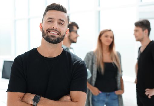 Business - team in an office, the junior manager is standing in front
