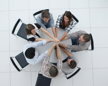 top view.the smiling business team folded their hands together.the concept of teamwork