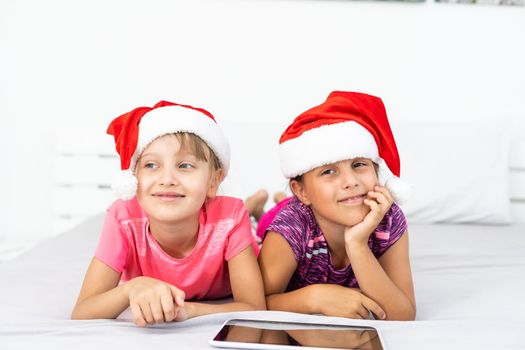 New year concept. christmas, x-mas, winter, happiness concept - two adorable cute girls playing with tablet pc.