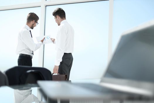 side view of businessmen shaking hands in office building