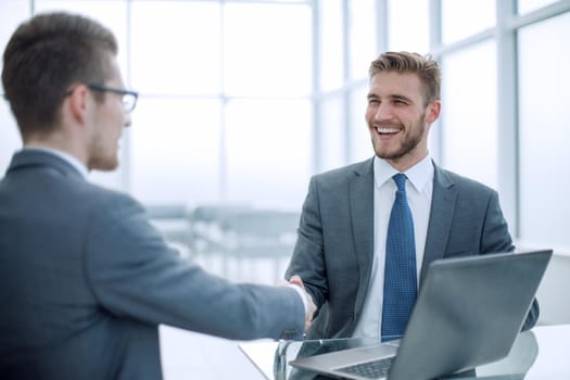 close up.smiling business people shaking hands in office.business concept