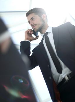 View from below of smart businessman speaking on cellular phone
