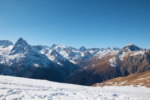 High quality photo about Dombay, alps, snow-covered slopes, the first snow in the mountains, sun and good weather, winter ski season