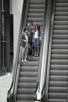 business people standing on the escalator in the business center