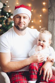 Portrait of beautiful father and little baby in the same sleepwears
