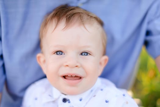 Closeup portrait of little male baby on blue t shirt background. Concept of childhood.