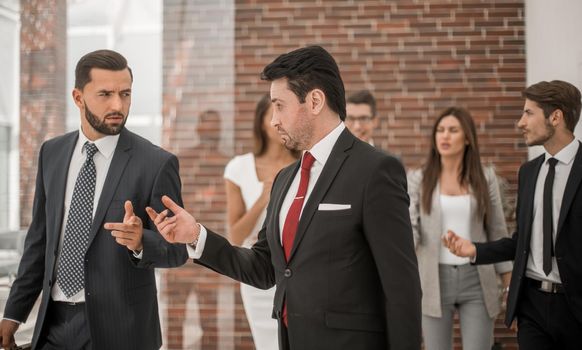 business colleagues are discussing something, walking along the office corridor .business concept