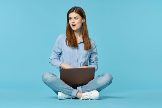 woman with laptop learning internet online education blue background. High quality photo