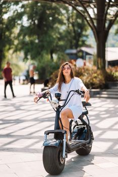 Young beautiful woman and an electric scooter, modern girl, new generation, electric transport, ecological transport