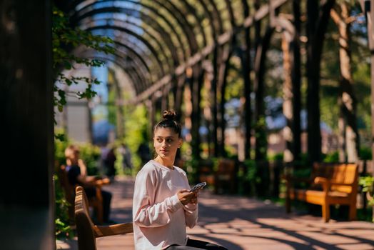 Woman walks along a picturesque alley in summer park.