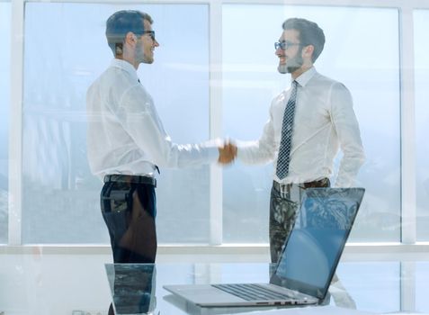 business people shake hands standing in a bright office.concept of partnership.