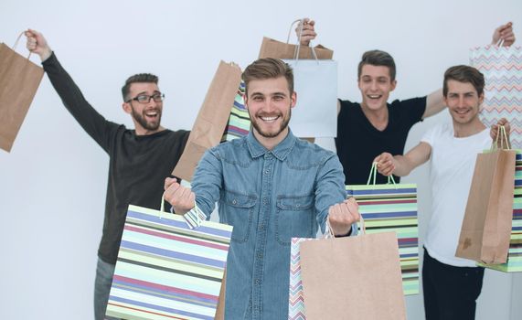 Paper colored bags in the hand of sales managers, isolated on white background. Seasonal sales for purchases.
