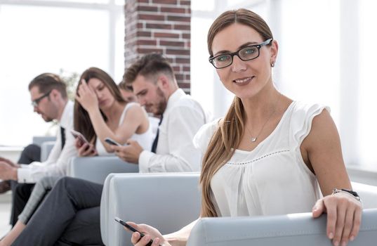 young business woman sitting in office waiting room.people and technology