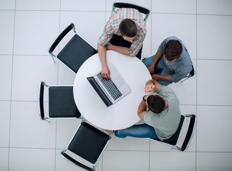group of people with gadgets sitting at a round table. people and technology