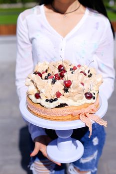 Young woman wearing white blouse keeping birthday cake. Concept of sweets and tasty food for party.