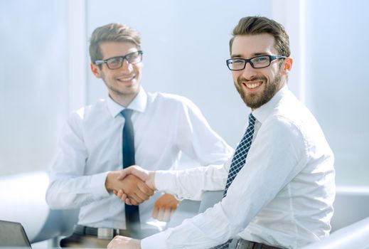successful employees shaking hands sitting at the Desk.photo with copy space