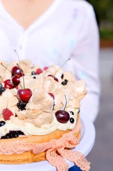 Closeup woman wearing white blouse keeping birthday cake. Concept of sweets and tasty food for party.