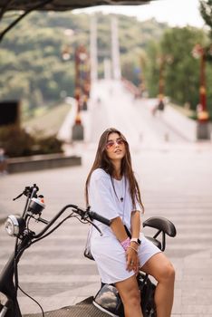 Young beautiful woman and an electric scooter, modern girl, new generation, electric transport, ecological transport