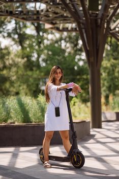 Young beautiful woman and an electric scooter, modern girl, new generation, electric transport, ecological transport