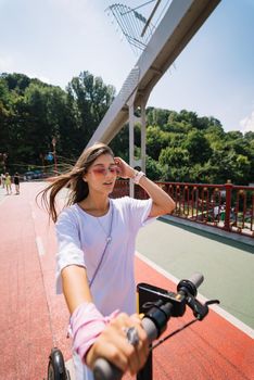 Young beautiful woman and an electric scooter, modern girl, new generation, electric transport, ecological transport