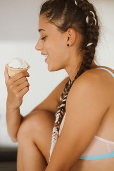Portrait of a sexy young woman eating cupcake on a white background