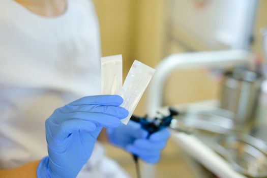 Closeup cosmetologist hands in latex gloves inserting needle into microblading device at beauty salon. Concept of cosmetology equipment for permanent makeup.