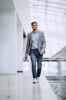 confident business man walks through a bright office. business concept
