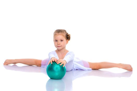 A charming little girl is engaged in fitness with a ball. The concept of gymnastics, health and sports. Isolated on white background.