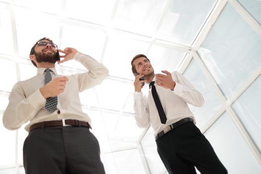 bottom view.two successful businessmen talking on their smartphones.business concept