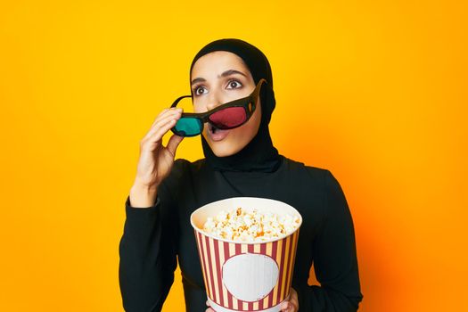 pretty woman in black hijab popcorn 3D glasses cinema ethnicity model. High quality photo