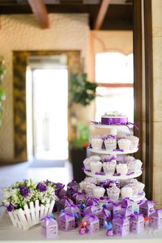 Violet decorations and sweet delicious cakes for party. Concept of birthday sweets and tasty food.