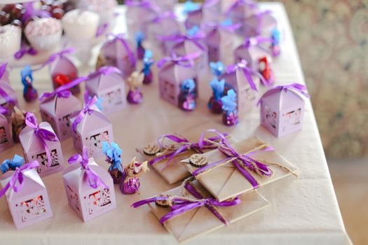 Nice violet decorations for birthday party, sweets and envelopes. Concept of congratulations and decor.