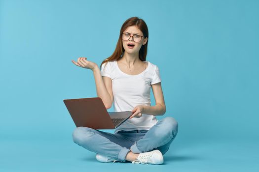woman with laptop learning internet online education blue background. High quality photo